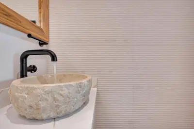 a bathroom with a stone sink with a faucet at Flamingo Marina Private Beachfront Escape in Playa Flamingo