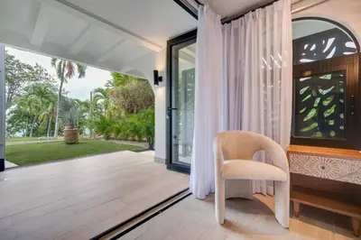 a dining room with a chair and a window at Flamingo Marina Private Beachfront Escape in Playa Flamingo