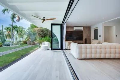 a living room with a white couch and a large window at Flamingo Marina Private Beachfront Escape in Playa Flamingo