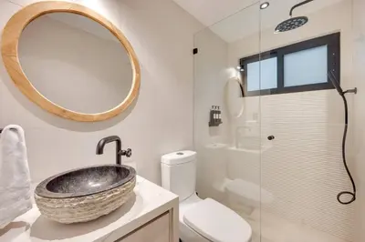 a bathroom with a sink and a toilet and a mirror at Flamingo Marina Private Beachfront Escape in Playa Flamingo