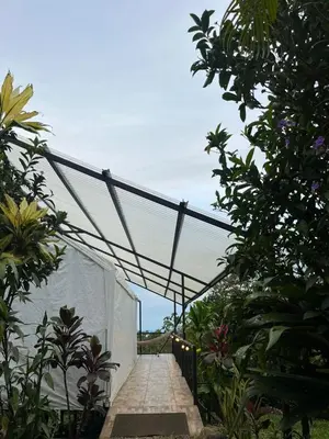 a walkway with a canopy in a garden at Glamping Finca garza del sol in El pilon