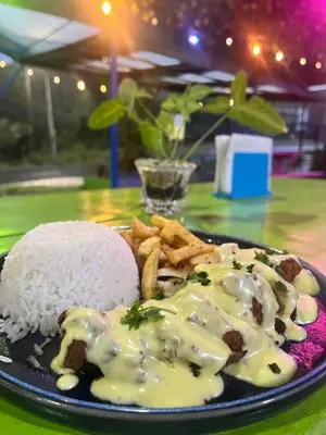 a plate of food with rice and cheese on a table at Glamping Finca garza del sol in El pilon