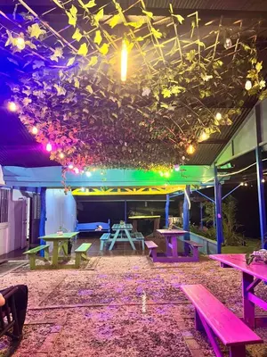 a patio with picnic tables and lights on the ceiling at Glamping Finca garza del sol in El pilon