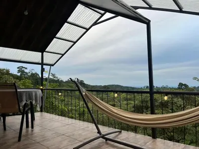 a hammock on a balcony with a view at Glamping Finca garza del sol in El pilon