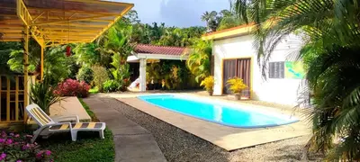 a swimming pool in front of a house at Villa Colibri at LakeGardens in Nuevo Arenal