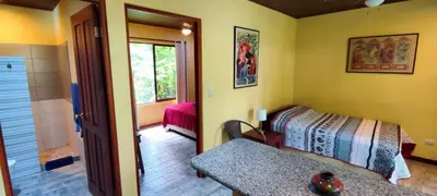 a room with a bedroom with a bed and a window at Villa Colibri at LakeGardens in Nuevo Arenal