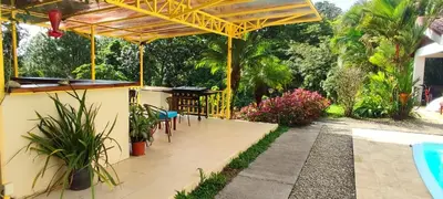 a patio with a table and chairs next to a pool at Villa Colibri at LakeGardens in Nuevo Arenal