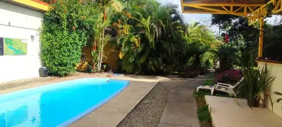 a swimming pool in front of a house with plants at Villa Colibri at LakeGardens in Nuevo Arenal