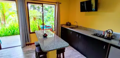 a kitchen with a counter and a large window at Villa Colibri at LakeGardens in Nuevo Arenal