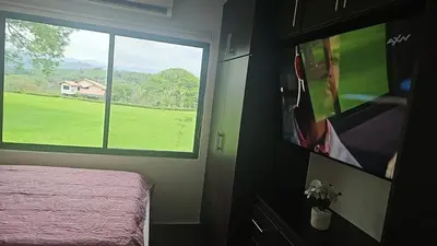 a bedroom with a tv and a bed and a window at Home Pura Vida With Cuban Flavor