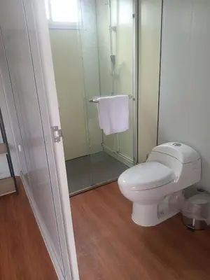 a bathroom with a toilet and a glass shower at Cabinas Nena in Esparza