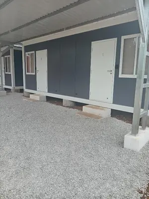 an empty garage with a blue wall and two doors at Cabinas Nena in Esparza