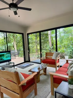 a living room with large windows and a tv at Casa Selva Pacifico in Quebrada Ganado