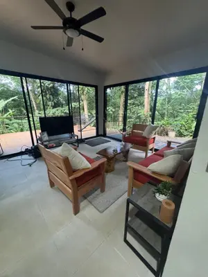 a living room with furniture and a ceiling fan at Casa Selva Pacifico in Quebrada Ganado