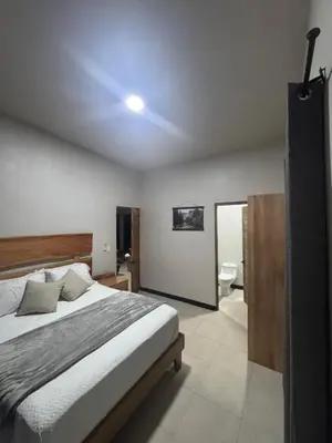 a bedroom with a large bed and a bathroom at Casa Selva Pacifico in Quebrada Ganado