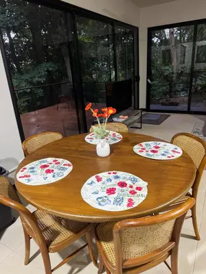 a wooden dining room table with four plates on it at Casa Selva Pacifico in Quebrada Ganado