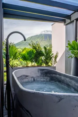 a bath tub with a view of a mountain at Cozy Volcano View Stay Brand New & Hot Tub in Fortuna