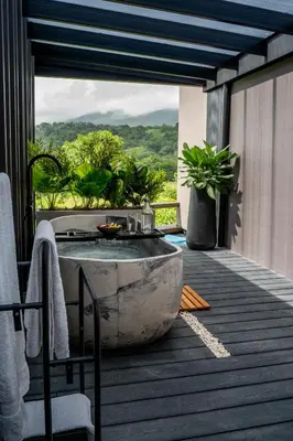 a tub on the deck of a house with a view at Cozy Volcano View Stay Brand New & Hot Tub in Fortuna