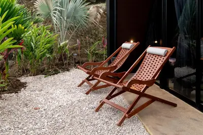 two rocking chairs sitting on a patio with plants at Charming Cabin in La Fortuna wHot Tub Brand new! in Fortuna