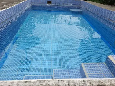 a swimming pool with blue tiles on the bottom of it at Casa Rústica Rancho de Lía- Vacacional in Orotina