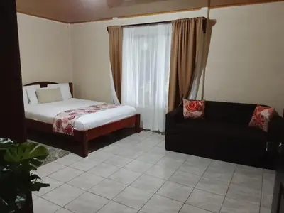 a living room with a bed and a couch at Casa Lago in El Castillo de La Fortuna