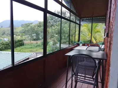 a room with a table and a chair on a balcony at Casa Lago in El Castillo de La Fortuna