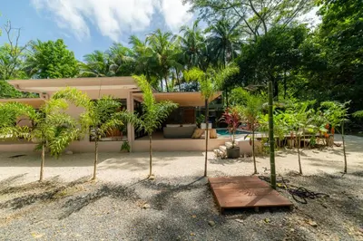 a house on the beach with trees in front of it at Casa Contento - luxury 3bdr home near Santa Teresa in Boca de Ario