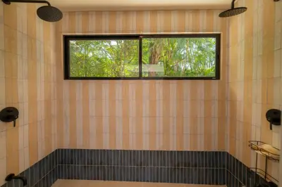 a bathroom with a window and a tiled wall at Casa Contento - luxury 3bdr home near Santa Teresa in Boca de Ario