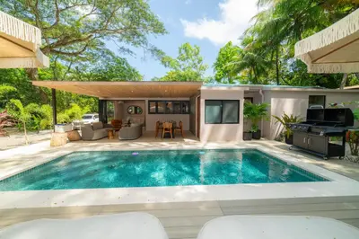 a swimming pool in the backyard of a house at Casa Contento - luxury 3bdr home near Santa Teresa in Boca de Ario