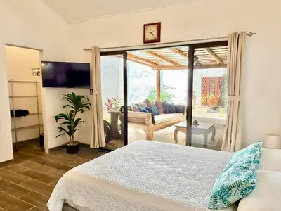 a bedroom with a bed and a living room at Passion For Surfing Apt Playa Guiones in Playa Guiones
