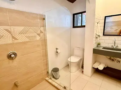 a bathroom with a shower and a toilet and a sink at Passion For Surfing Apt Playa Guiones in Playa Guiones