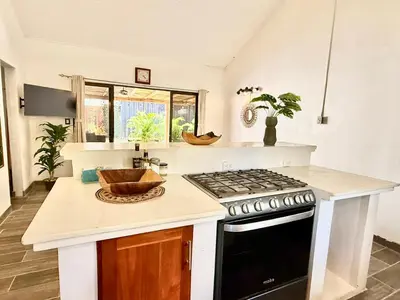 a kitchen with a stove and a counter top at Passion For Surfing Apt Playa Guiones in Playa Guiones