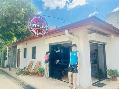 two men are standing outside of a building at Passion For Surfing Apt Playa Guiones in Playa Guiones