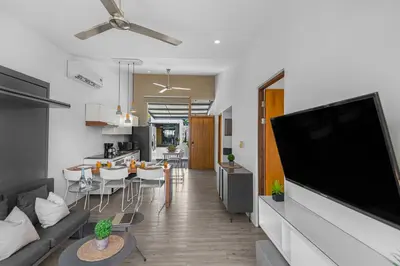 a living room and kitchen with a large flat screen tv at Jacó Condo 2 BR, Pool & families in Jacó