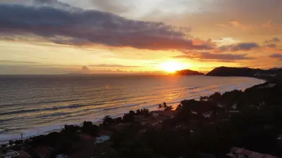 a sunset over the ocean with the sun setting at Jacó Condo 2 BR, Pool & families in Jacó