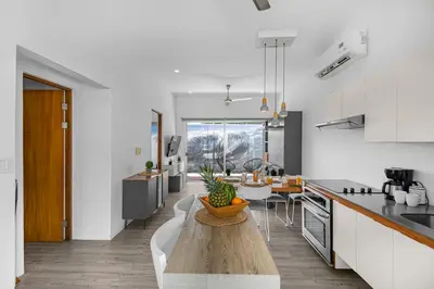 a kitchen with a table with a bowl of pineapple on it at Jacó Condo 2 BR, Pool & families in Jacó