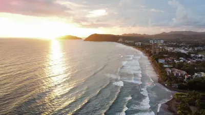 an aerial view of the beach at sunset at Jacó Condo 2 BR, Pool & families in Jacó