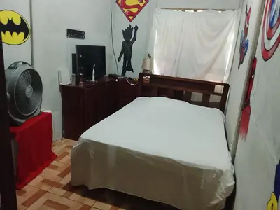 a bedroom with a bed and a window with a batman sign at Casa Victoria in Ojochal
