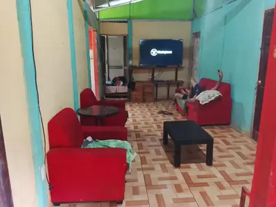 a living room with two red chairs and a tv at Casa Victoria in Ojochal