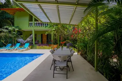 a patio with a table and chairs next to a pool at Casa Aloha on Los Mangos Street in Nosara