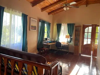 a living room with a desk and a chair at Casa Aloha on Los Mangos Street in Nosara