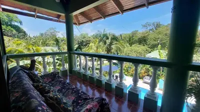 a room with a balcony with a view of the ocean at Casa Aloha on Los Mangos Street in Nosara