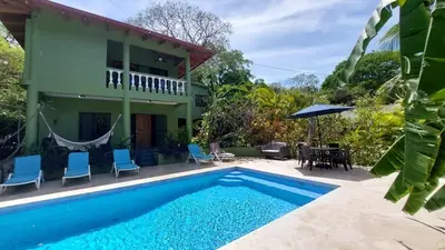 a villa with a swimming pool and a house at Casa Aloha on Los Mangos Street in Nosara