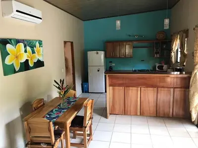 a kitchen with a table and a refrigerator at Casa Plumeria-Aloha Surf Nosara in Nosara