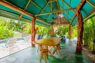 a wooden table and chairs on a patio at Casa Plumeria-Aloha Surf Nosara in Nosara