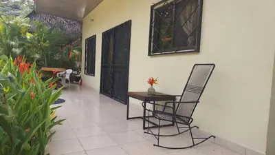 a patio with two chairs and a table and a door at Casa Plumeria-Aloha Surf Nosara in Nosara