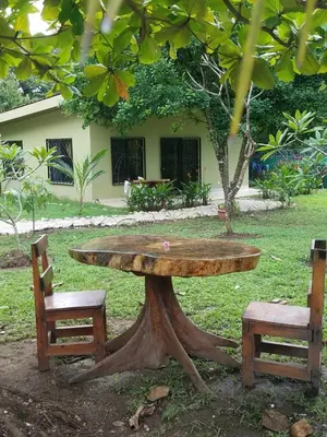 a large wooden table and two chairs in a park at Casa Mango- family friendly 2 Bedroom, 2 Bath in Nosara