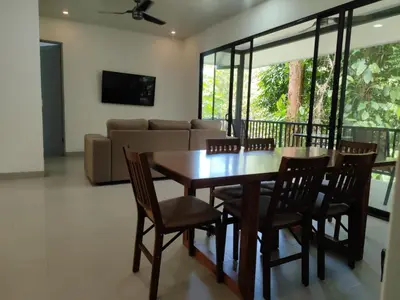 a dining room with a table and chairs and a couch at Villa del Río in Savegre