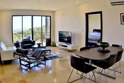 a living room with a table and chairs and a television at The Luxury Condo at Reserva Conchal, Great Beach in Playa Conchal
