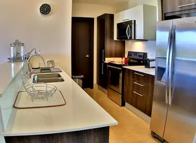 a kitchen with a sink and a refrigerator at The Luxury Condo at Reserva Conchal, Great Beach in Playa Conchal